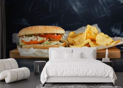 Chiken burgers on wooden tray. Two Homemade hamburgers, pickles and chips on a black metal background. Baking paper Wall mural