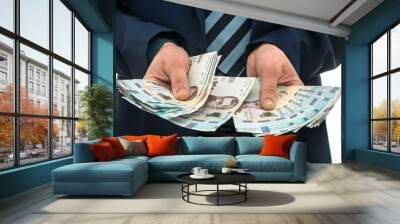 businessman made huge profits, showing a lot of money. a man in a suit holds a pack of new banktons  Wall mural