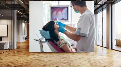 Doctor examining patient's teeth with intraoral camera Wall mural