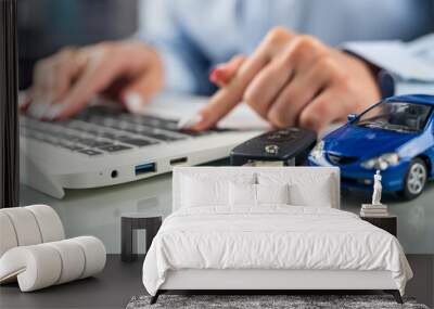 hands of a woman on a desk behind a keyboard with a small model car. Wall mural