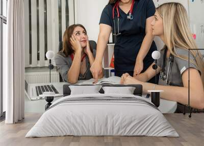 Team of happy female doctors or nurse meeting at hospital office Wall mural