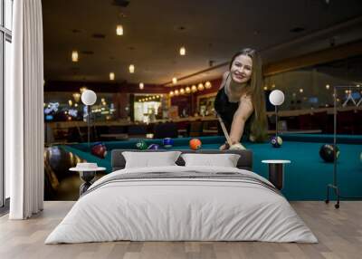 Young and beautiful woman in pub playing billiard Wall mural