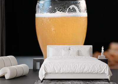 glass of beer on a light table in a pub with a snack on a dark background Wall mural