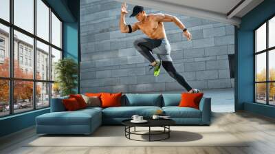 Sporty man running. Side view of active man training in the city. Dynamic movement. Sports and healthy lifestyle Wall mural