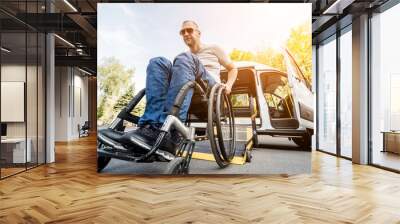 A man in a wheelchair on a lift of a vehicle for people with disabilities Wall mural