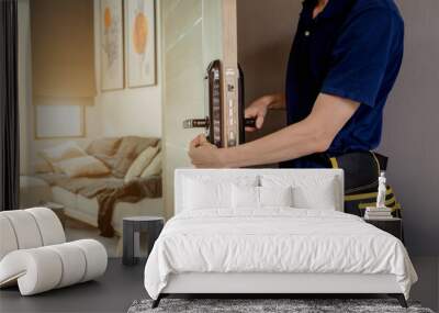 A technician installs a modern smart door lock on the wood door Wall mural