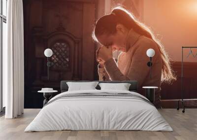 Christian woman praying in church. Hands crossed and Holy Bible on wooden desk. Wall mural