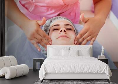 Facial cosmetic procedure in spa salon. The procedure for applying a mask to the face of a beautiful woman Wall mural