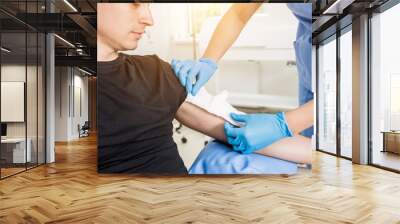 Nurse dressing wound for patient's hand with burn injury Wall mural