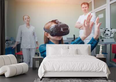 Ophthalmology doctor checks the girl's vision with the help of virtual reality goggles. Wall mural