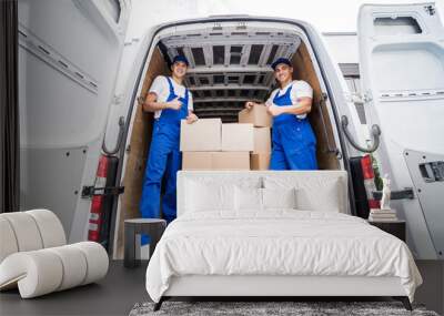 Two removal company workers unloading boxes from minibus Wall mural