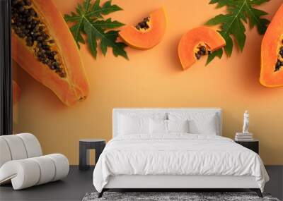 Cut Papaya over orange table background for tropical fruit design concept. Wall mural