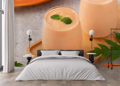 Delicious papaya milk smoothie in glass cup on gray table background Wall mural