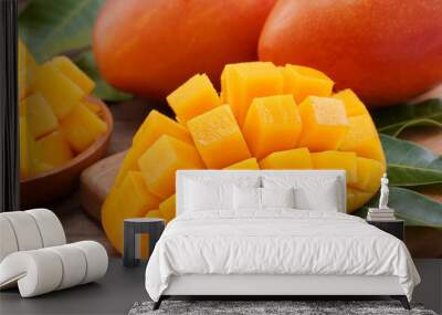 Fresh mango, beautiful chopped fruit with green leaves on dark wooden table background. Tropical fruit design concept. Flat lay. Top view. Copy space Wall mural