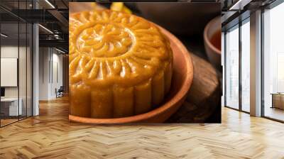 Mooncake, Moon cake for Mid-Autumn Festival, concept of traditional festive food on black slate table with tea and yellow flower, close up, copy space. Wall mural