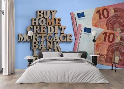 Words on a white background lined in the form of a house of wooden letters next to two bills of 10 euros. The concept of buying real estate on credit through a bank mortgage. Wall mural