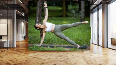 Fitness woman doing yoga exercise and relax with sportswear in green park at summer, healthy lifestyle concept. Wall mural