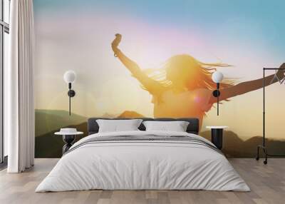 Girl on a background of mountains joyful spread her arms dancing at a height Wall mural