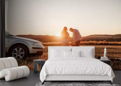 Happy Young Family Mom and Dad with Their Little Son Enjoying Summer Weekend Picnic on the Car Outside the City in the Field at Sunny Day Sunset, Vacation and Road Trip Concept Wall mural