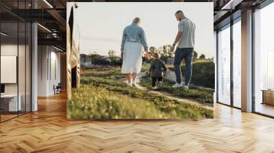 Mother and Father Help Their Toddler Son Take the First Steps, Family Road Trip Weekend Wall mural