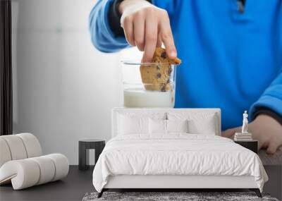 close up of a child dunking a cookie in a glass of milk Wall mural