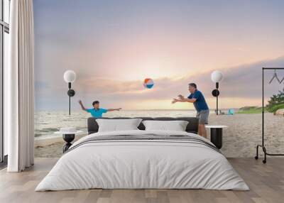 Father and son playing with a ball on the beach Wall mural