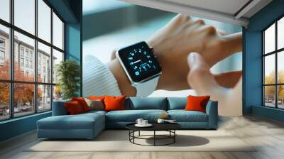 A person checking a notification on their smartwatch with a black background and red light. Wall mural