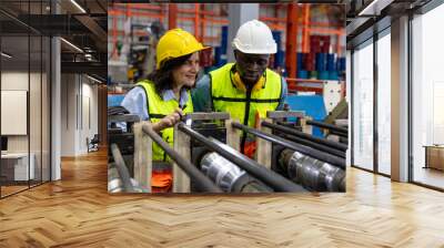 Female mechanical engineer is coaching and providing support to her trainee while examining the functions of metal machines in a factory. Teamwork between two engineers in a factory production plant Wall mural