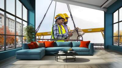 Two civil engineers are in safety uniform standing on a platform checking progress over a construction site Wall mural