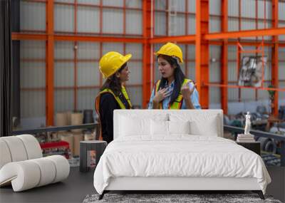 two female mechanical engineers from different ethnicities and cultures having a discussion over a p Wall mural