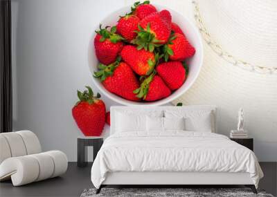 bowl of fresh strawberries with sun hat on white Wall mural