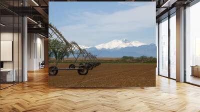 pivot irrigation system in a farming field with longs peak mountain in the background Wall mural