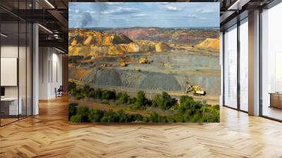 Excavator and heavy mining dump trucks in a limestone quarry, loading of stone or industrial aerial panorama view. Wall mural