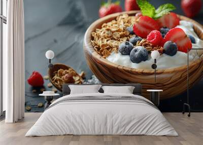 A wooden bowl filled with greek yogurt, granola and fresh fruits on a dark background Wall mural