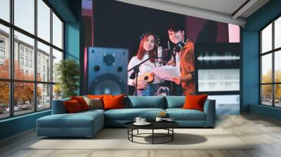 Asian couple singers in a recording studio using a studio microphone with passion in music recording studio Wall mural