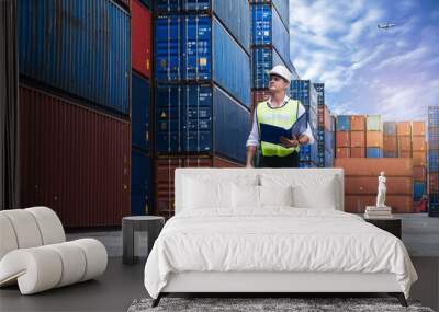 Foreman holding document, walking and checking the containers box from cargo ship for export and import Wall mural