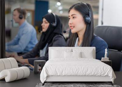 Happy smiling operator asian woman customer service agent with headsets working on computer in a call center, talking with customer for assisting to resolve the problem with her service mind Wall mural