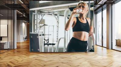 Attractive young woman taking a break after exercise at the gym Wall mural