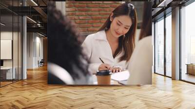 Businesswoman signing contract as members of investment group. Wall mural