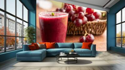 Glass of Grape juice smoothie on wooden table Wall mural