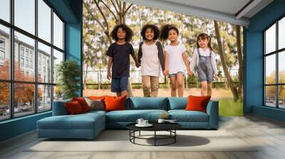 Group of children having fun playing together. Kids holding hands and walking in a park. Wall mural