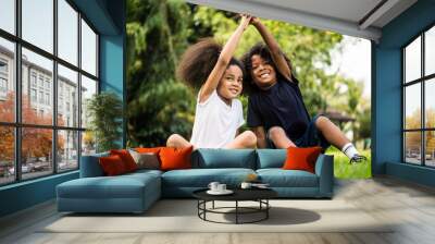 Little boy and girl playing together in a park Wall mural