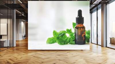 aromatherapy treatment - essential oil bottle with mint leaves on clean bright background with copy space Wall mural