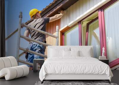 construction worker on scaffolding painting wooden house facade Wall mural