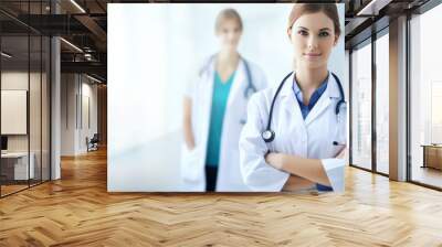 female doctor in white coat standing in hospital corridor with medical workers team in background. banner with copy space. generative AI Wall mural