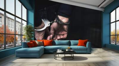 handcuffed arrested man behind prison bars. copy space Wall mural