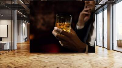 man wearing suit sits in the luxury bar in gentlemen club and drink whiskey. copy space Wall mural