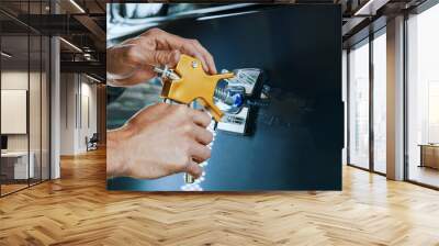 paintless car dent repair tool. man fixing vehicle door with PDR technology Wall mural