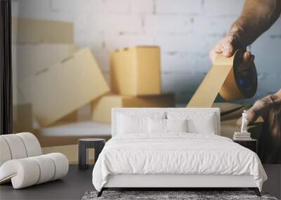 warehouse order picker packing and sealing cardboard box with tape for dispatch Wall mural