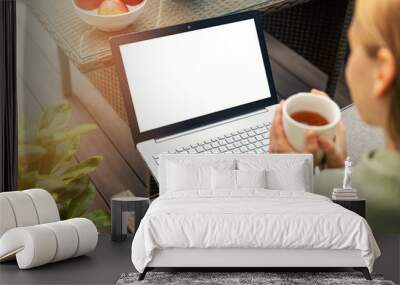 woman drinking tea and using laptop on a outdoor terrace, blank screen copy space Wall mural